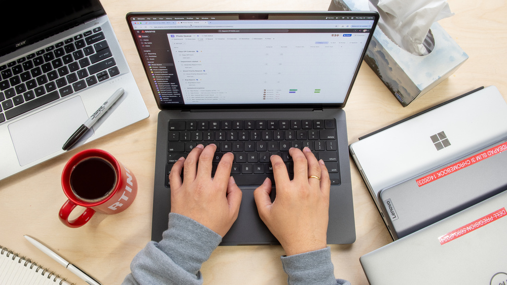 Overhead view of a laptop and coffee mug on a home office desk