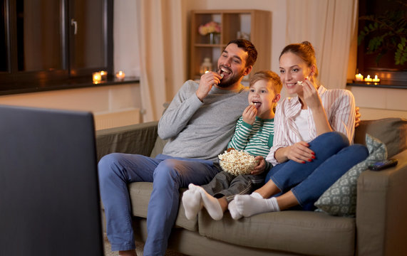 American family watching television together on a sofa at home